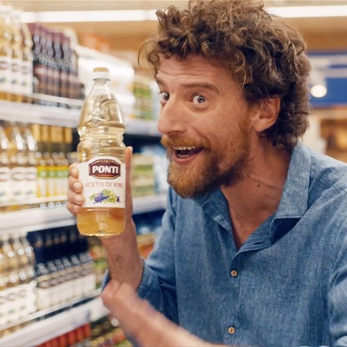 Maurizio Lastrico al supermercato recita con una bottiglia di aceto bianco Ponti