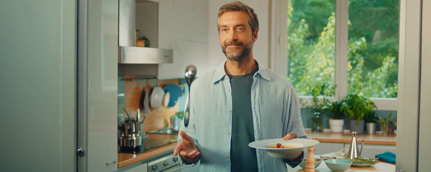 Frame dello spot Piccolo Gesto Grande Impatto realizzato in casa. Uomo in cucina maneggia una tovaglietta ecologica